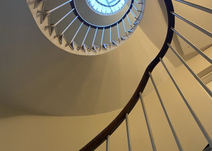 Spiraltrappe med loftsvindue set nedefra i et oplyst rum